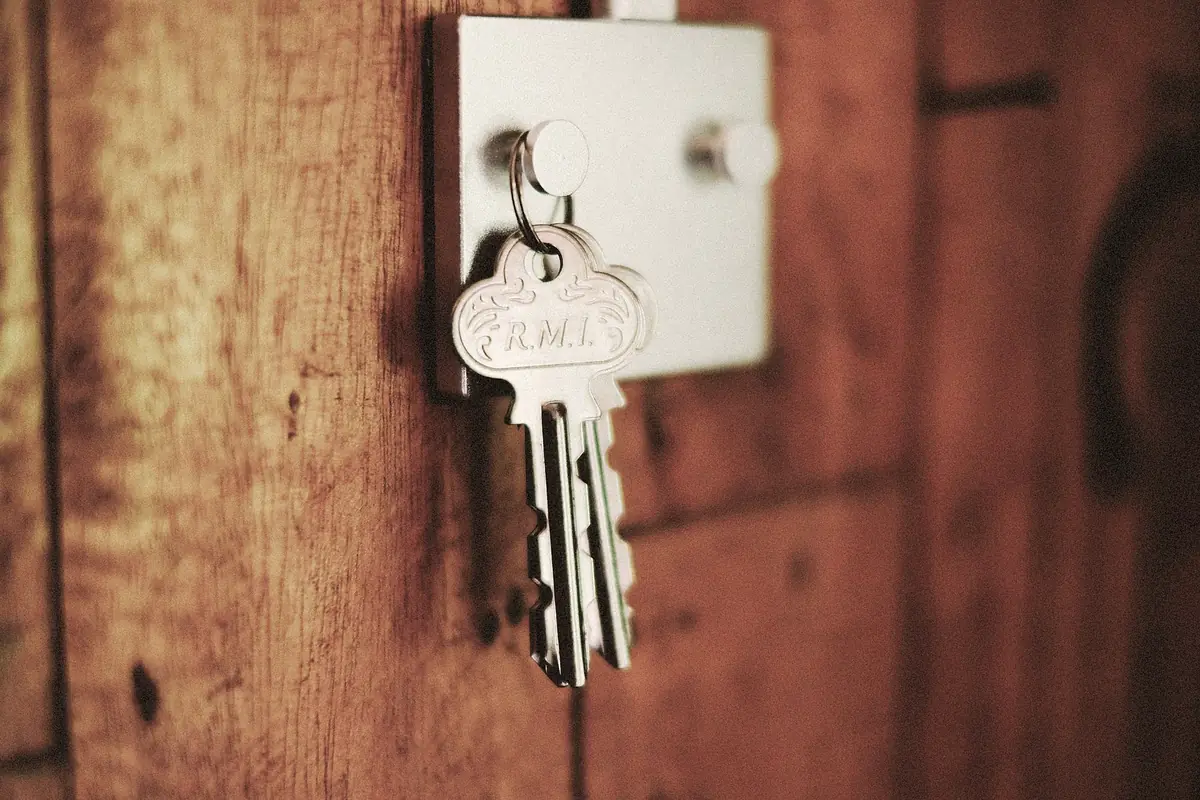 A set of keys left hanging in the lock of a weathered wooden door.